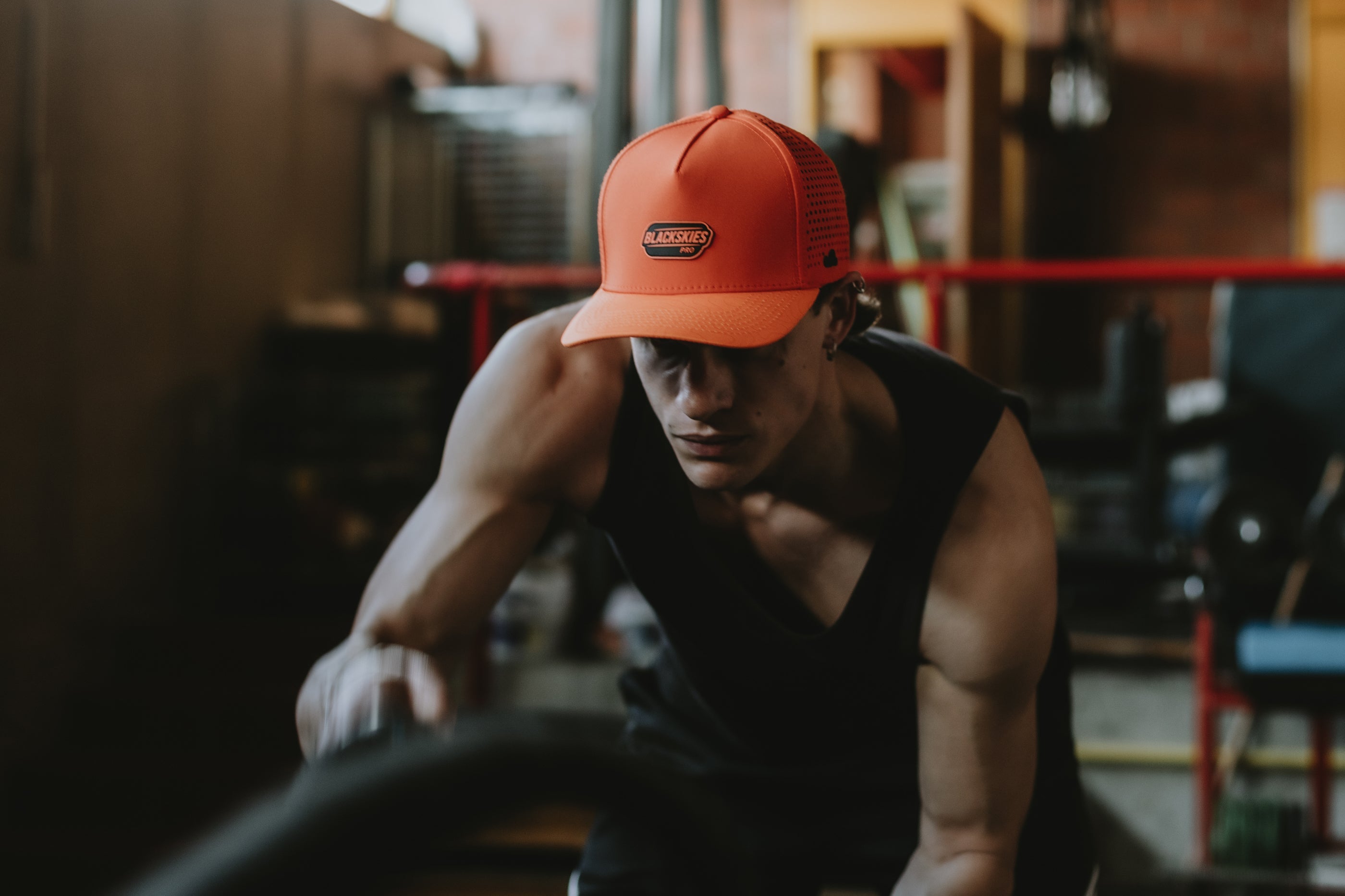 Athlet wearing an orange sport performance cap in a gym setting