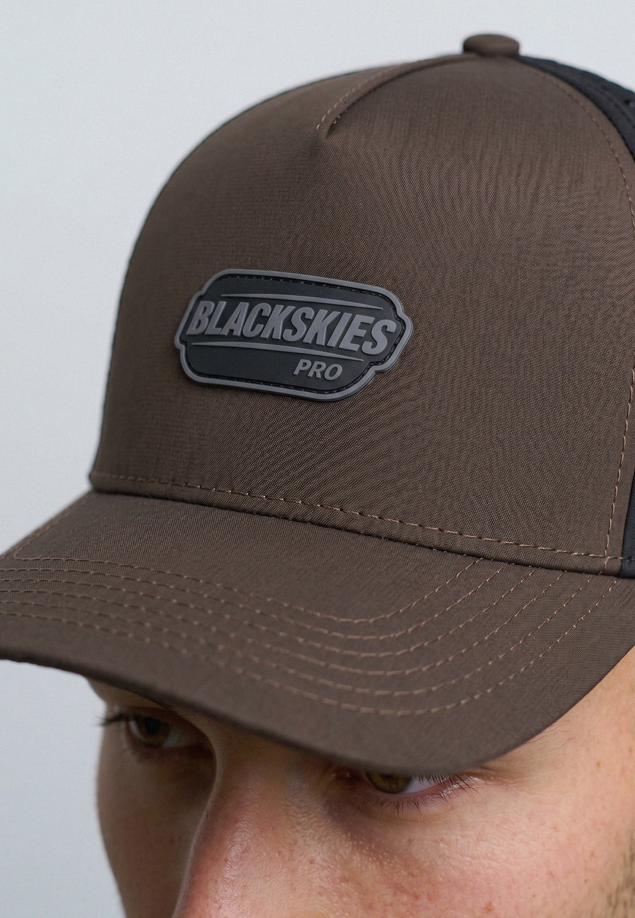 Brown cap with Blackskies Pro logo on a gray background