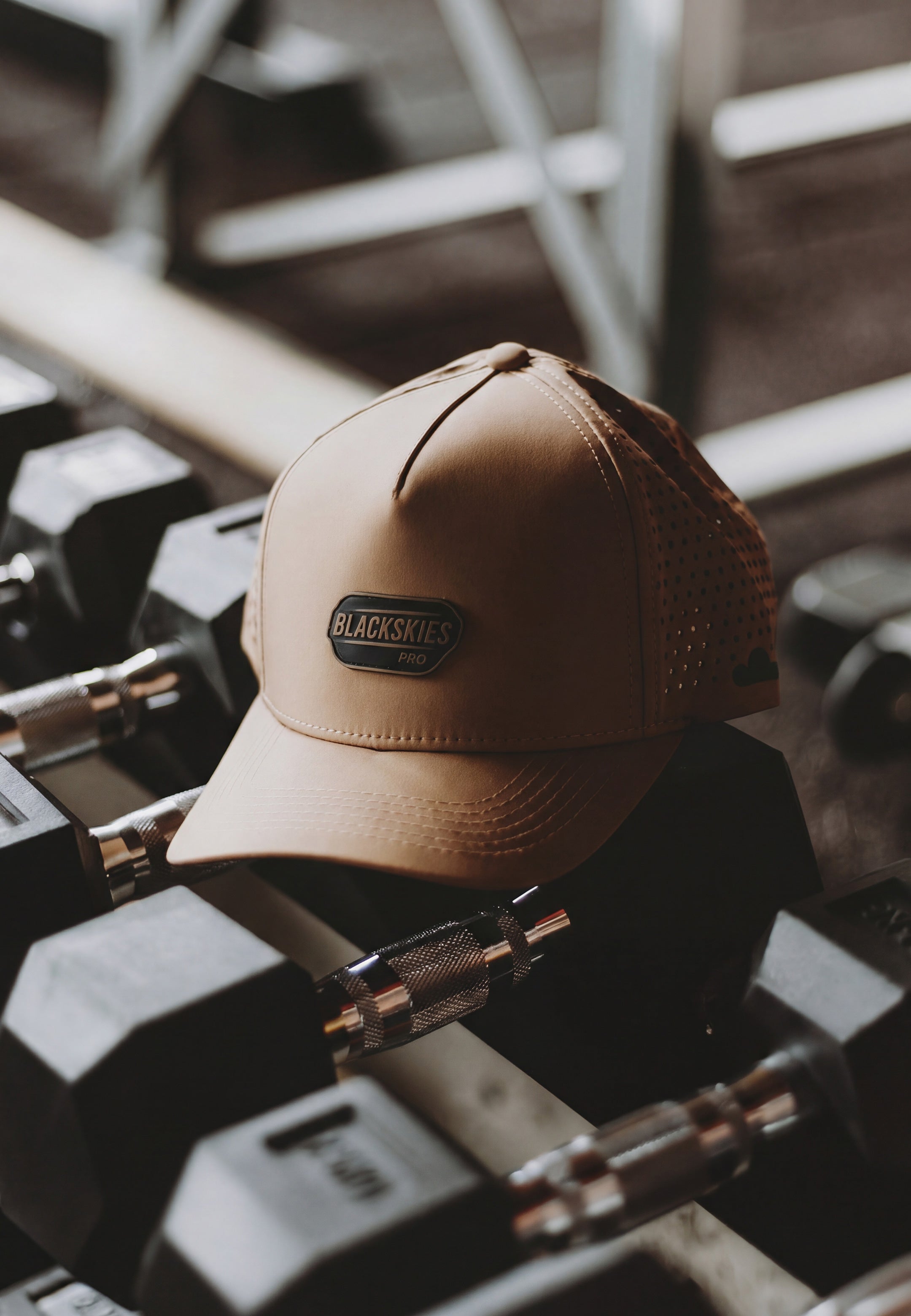 Brown sport cap with a brand logo on top of dumbbells