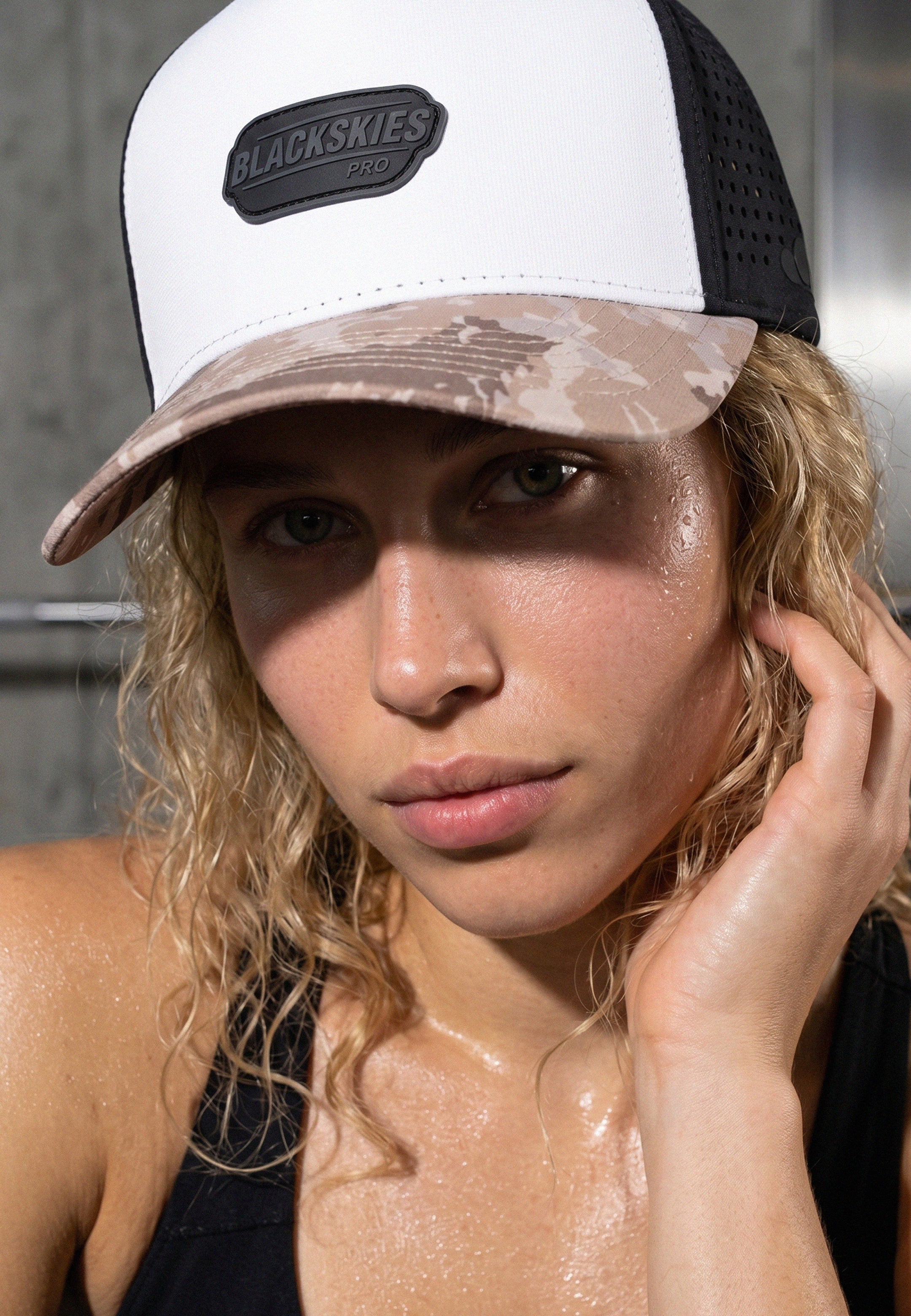 Woman wearing a cap with 'Blackskies' branding, outdoors.