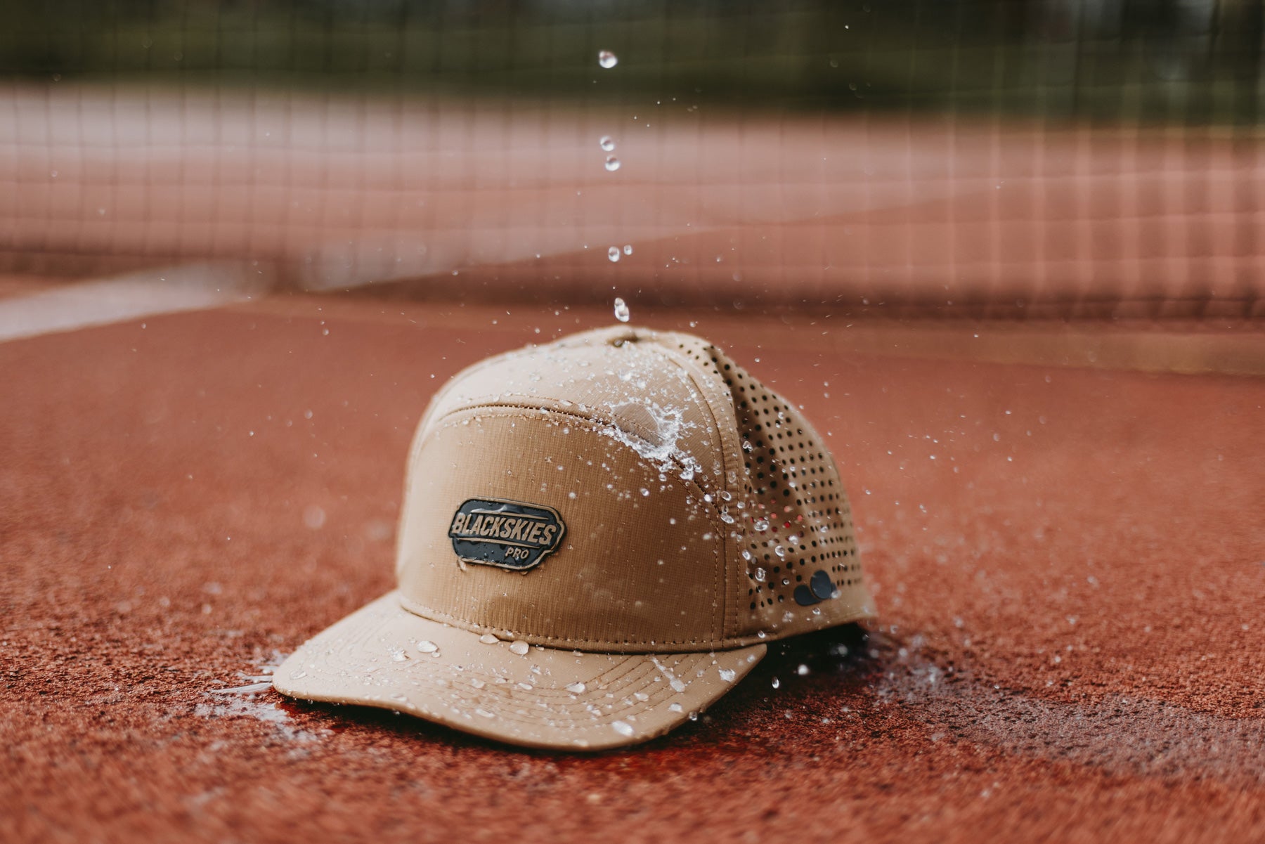 Brown cap with a logo water repellent on a tennis court