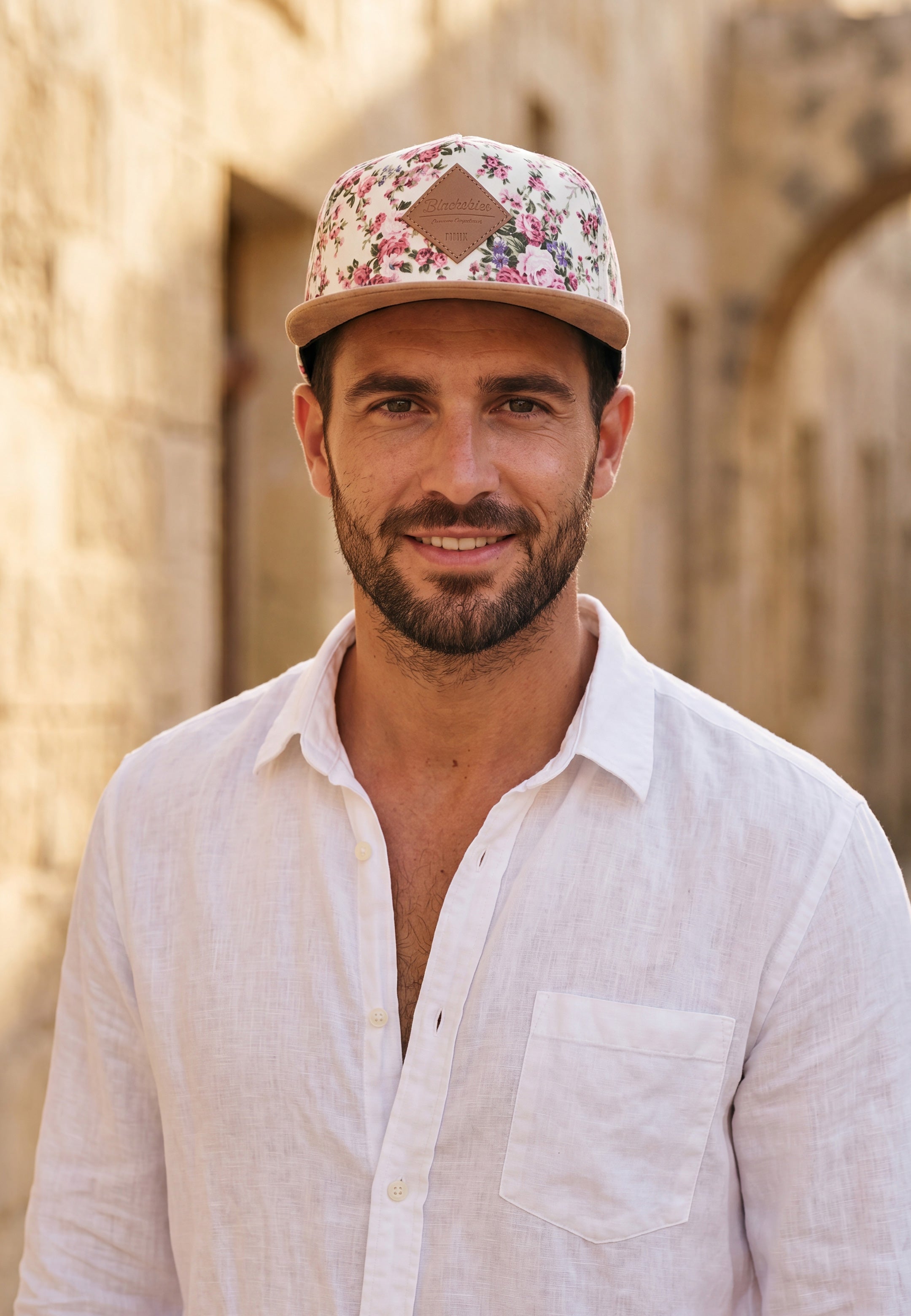 Man wearing a floral cap and white shirt outdoors