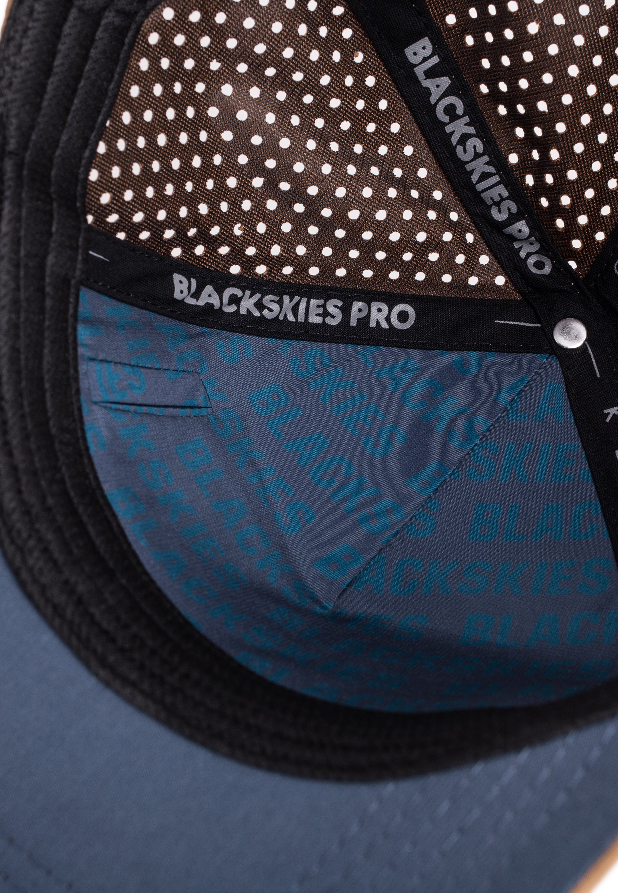 Close-up of a blue cap with 'Blackskies Pro' branding on a white background